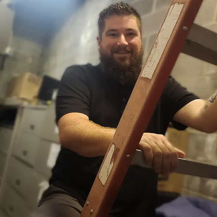 Technician on a ladder installing access control cabling at Clark Building Technologies.